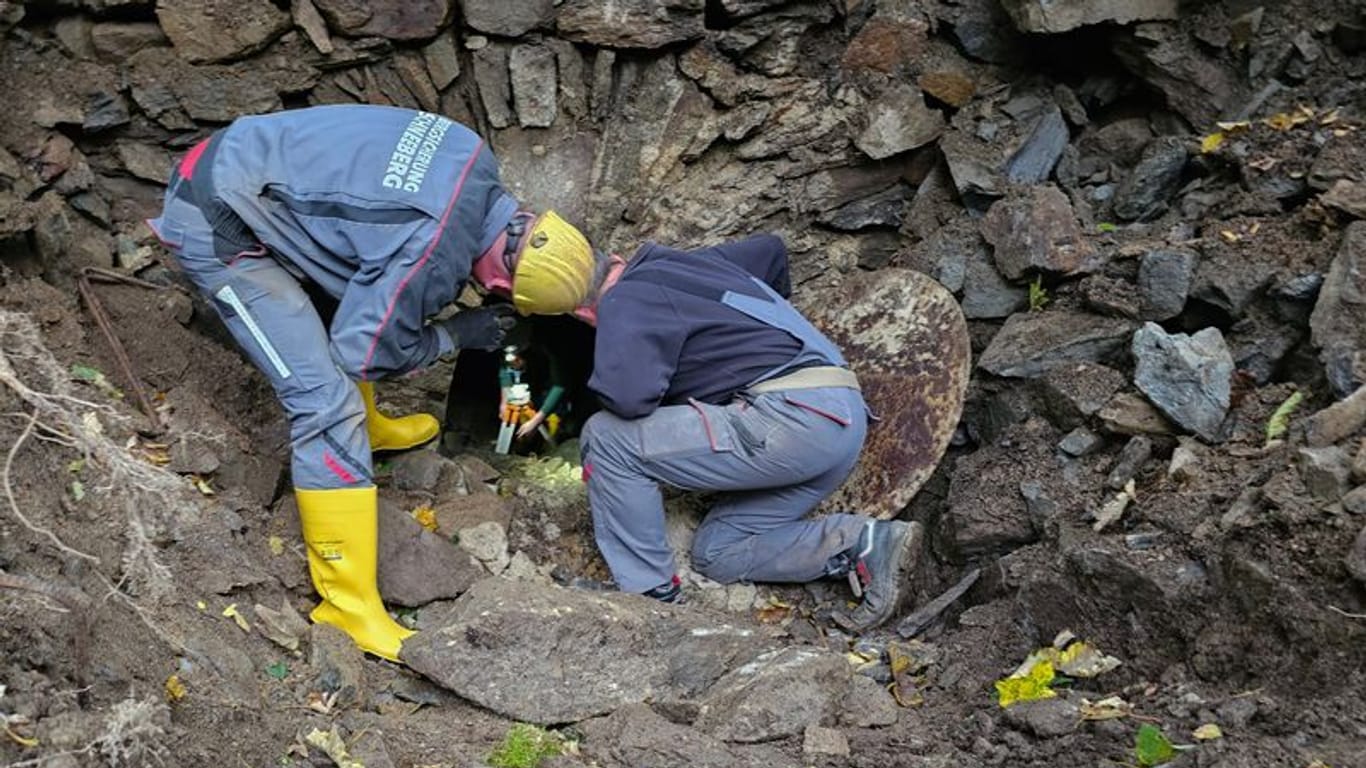 Mitarbeiter einer Firma zur Bergsicherung arbeiten in einem Areal in einem Waldstück. Ein in einem alten Bergwerksstollen im Erzgebirge mutmaßlich verschwundener Mann blieb vermisst. (Archivbild)