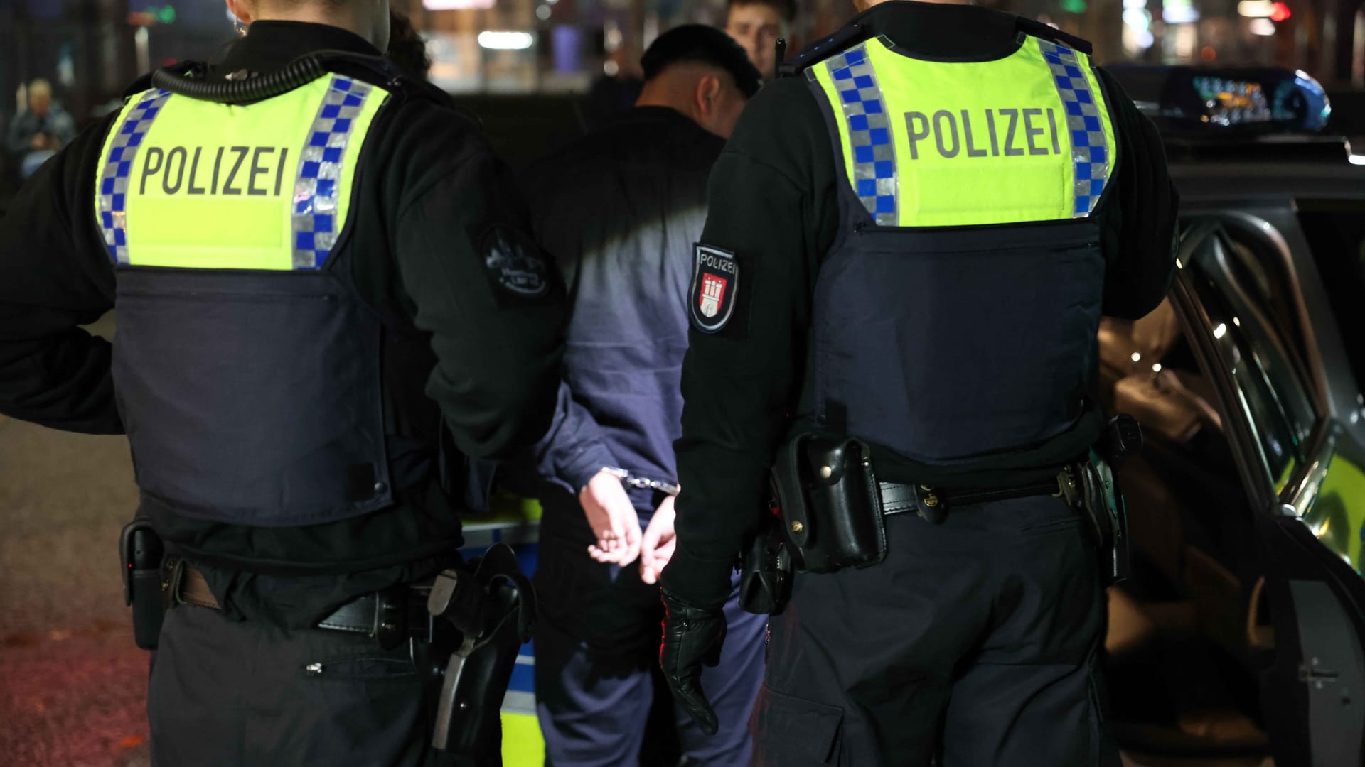 Polizisten nehmen einen jungen Mann fest (Symbolbild): In Köln sind an Halloween mehr Einsatzkräfte unterwegs.