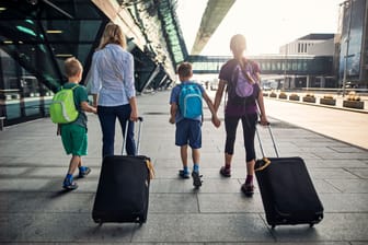 Zwei Mütter mit ihren Kindern auf dem Weg in den Urlaub