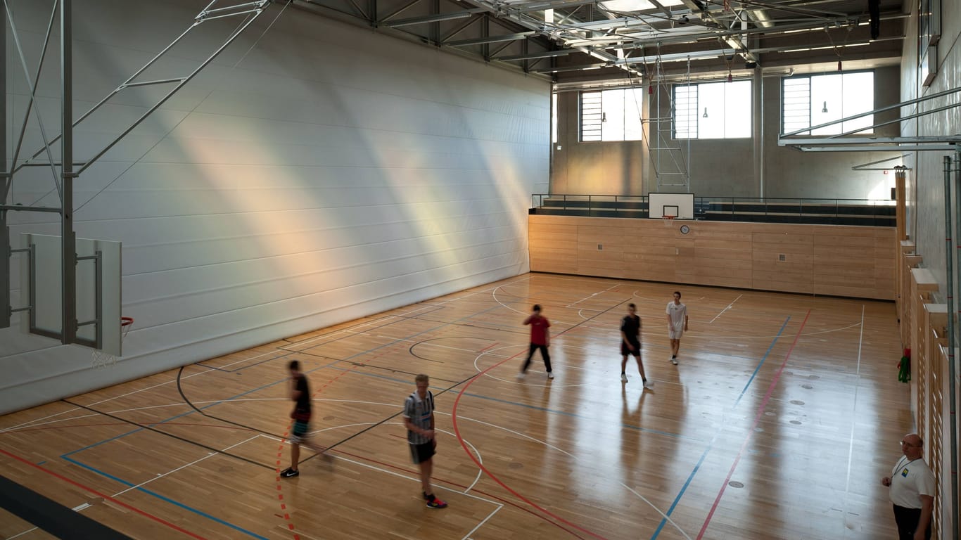 Menschen in einer Sporthalle (Symbolbild): Wohl noch bis zu den Herbstferien muss der Hallenwächter vor Ort seinen Dienst schieben.