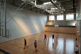 Menschen in einer Sporthalle (Symbolbild): Wohl noch bis zu den Herbstferien muss der Hallenwächter vor Ort seinen Dienst schieben.