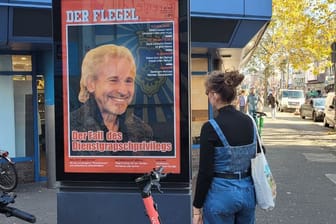 Eine Passantin blickt auf ein Plakat der Gruppe an der Venloer Straße.