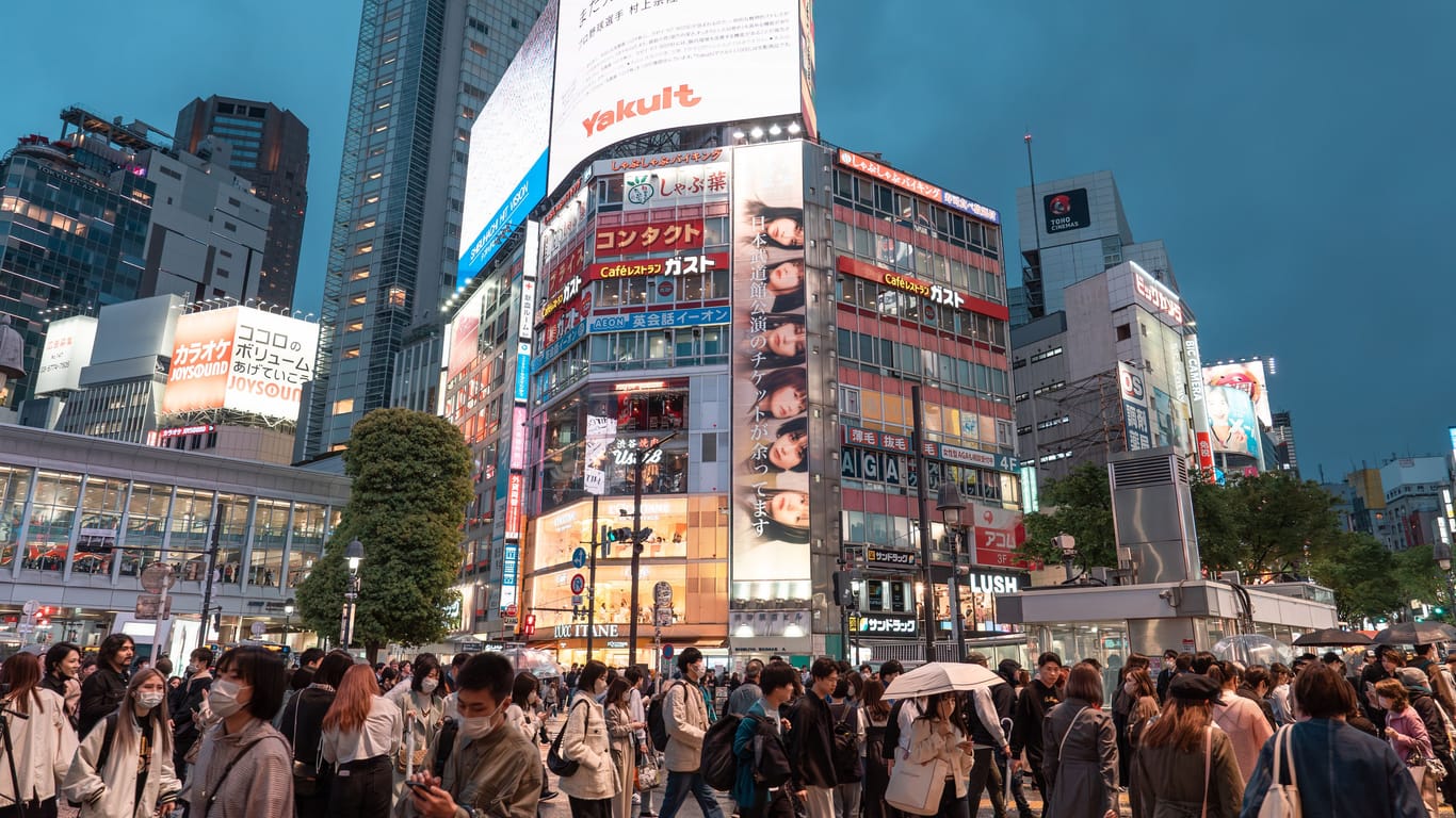 TOKYO, JAPAN - APRIL 8, 2023: View of Shibuya Crossing, one of the busiest crosswalks in the world in a raining day