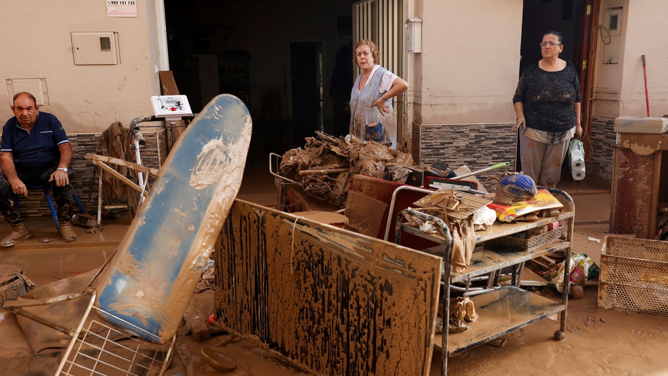 Menschen klauben die Reste ihres Inventars aus ihren Häusern in Guadassuar, in der Region Valencia.