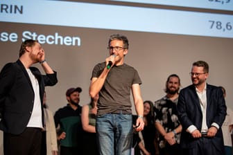 Vorjahressieger René Greschert (Mitte) neben den Moderatoren der Landesmeisterschaft im Poetry Slam 2023 in Krefeld, Johannes Floehr (Links) und Bernard Hoffmeister (Rechts)