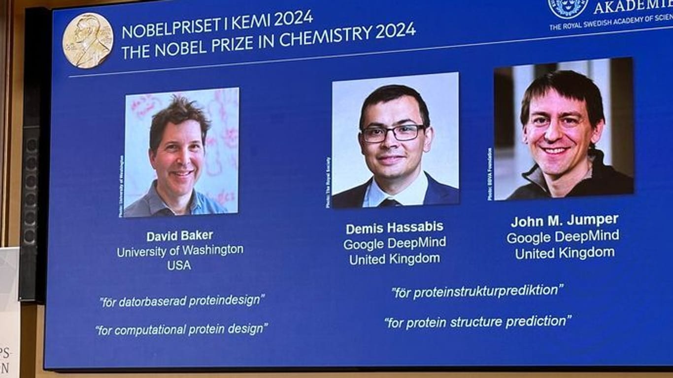 Drei Forscher teilen sich den Preis: Auf der Leinwand während der Pressekonferenz zur Bekanntgabe des Chemie-Nobelpreises 2024 werden Bilder von David Baker, Demis Hassabis, und John M. Jumper gezeigt.