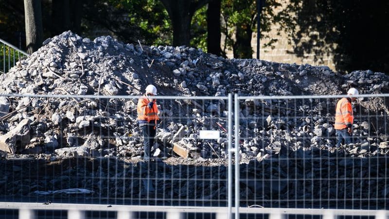 Arbeiter stehen auf der Altstädter Elbseite vor Trümmerteilen des eingestürzten Brückenzuges der Carolabrücke: