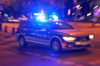 Ein Einsatzwagen der Polizei fährt mit Blaulicht bei Nacht zu einem Einsatz (Symbolfoto): Ein 35-Jähriger ist bei einer Rangelei bewusstlos geworden und schwebt in Lebensgefahr.