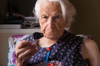 Eine ältere Frau ,mit einem Glas Wasser: Gerade Senioren sind von Unterernährung bedroht.