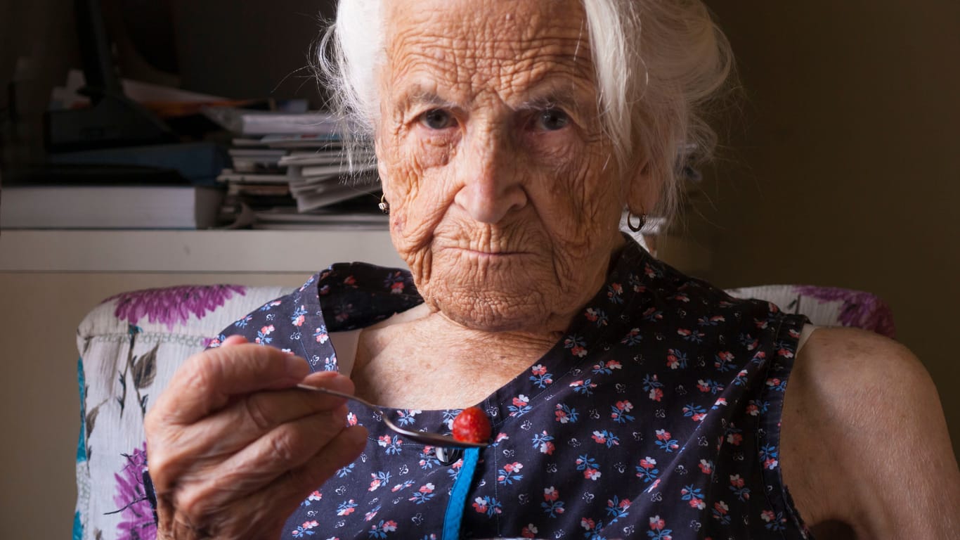 Eine ältere Frau ,mit einem Glas Wasser: Gerade Senioren sind von Unterernährung bedroht.