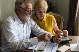 Rentnerpaar erledigt seine Finanzen: Auch im Ruhestand werden Beiträge an die Krankenversicherung fällig.