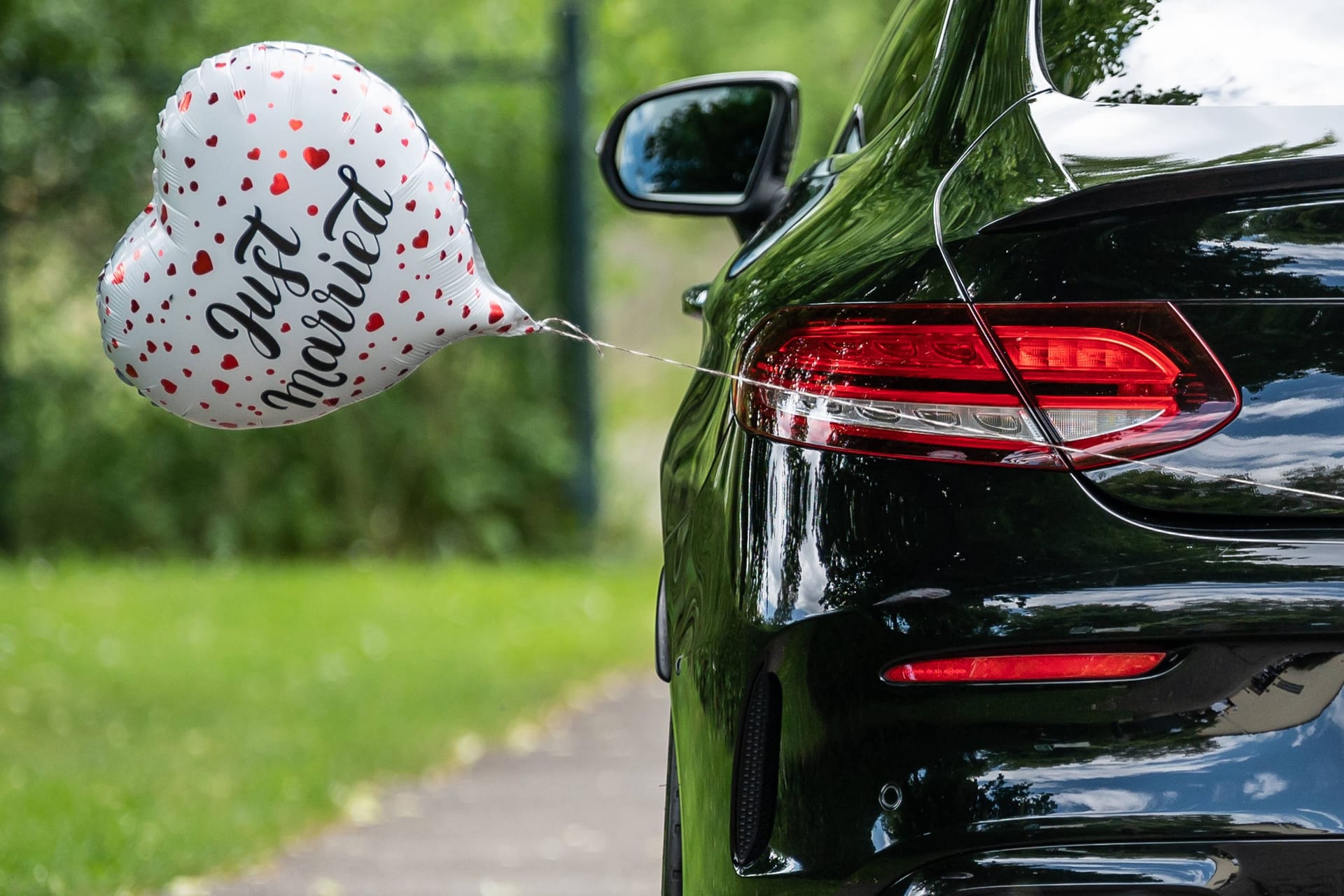 Ein Herz-Luftballon mit der Aufschrift "Just Married" hängt an einem Auto (Symbolbild): Ein Hochzeitskorso hat in Delmenhorst Ärger verursacht.