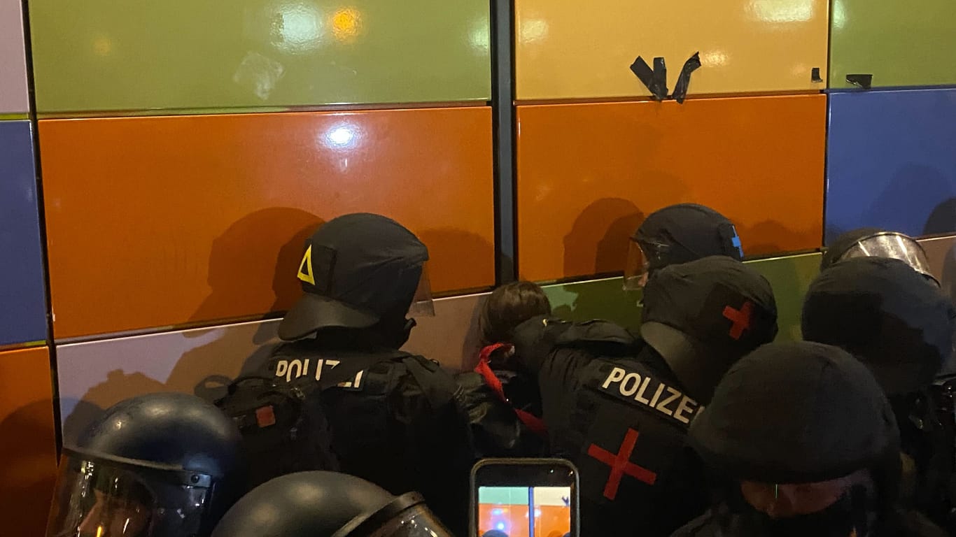 Polizisten halten eine Person fest.