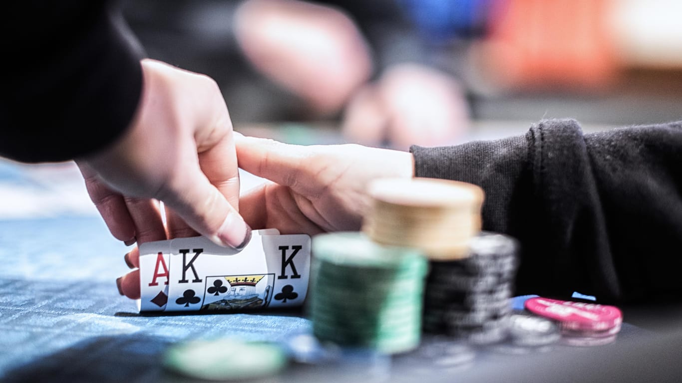 Personen spielen Poker (Symbolbild): Die Polizei ermittelt wegen des Verdachts des Veranstaltens eines illegalen Glücksspiels.