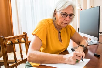 Eine ältere Frau schreibt ihr Testament (Symbolbild): 71 Prozent der Deutschen haben ihr Erbe noch nicht geregelt.