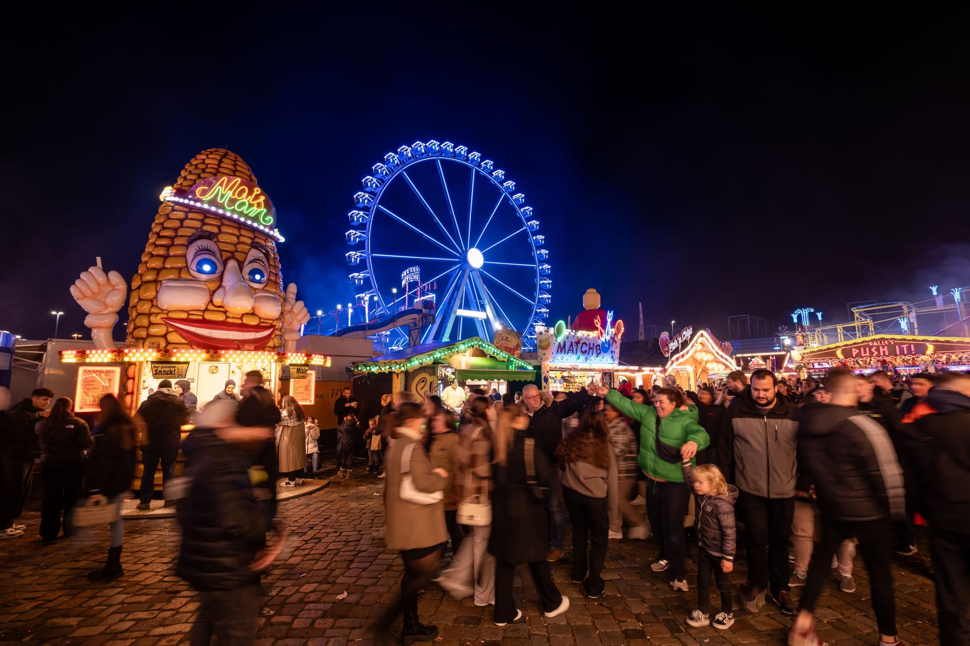 Die Fahrgeschäfte und Buden auf dem Freimarkt leuchten mit bunten Lichtern: Reizüberflutung ist Programm.