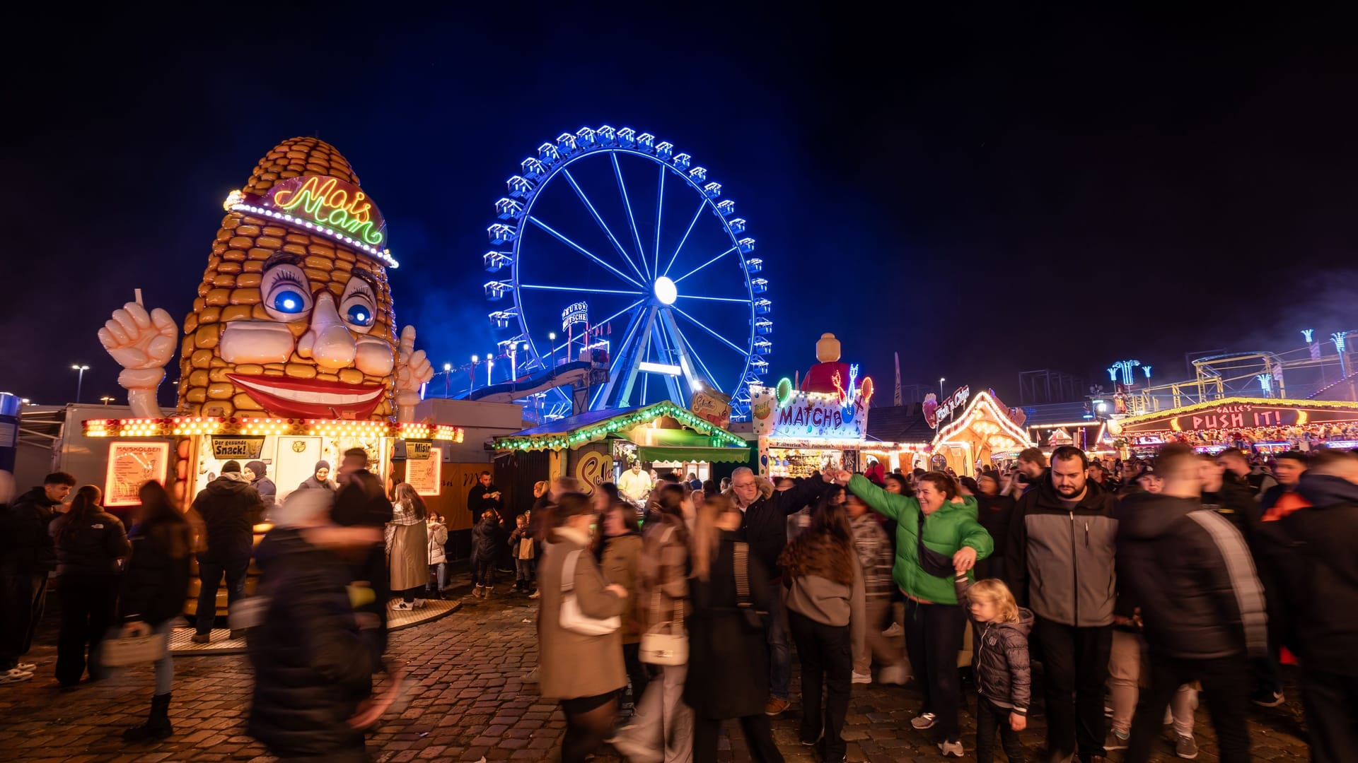 Die Fahrgeschäfte und Buden auf dem Freimarkt leuchten mit bunten Lichtern: Reizüberflutung ist Programm.