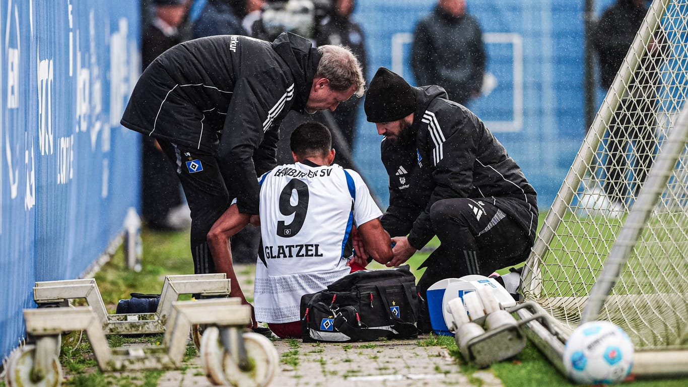 Robert Glatzel sitzt am Boden: Die HSV-Mediziner kümmern sich um den verletzten Stürmer.