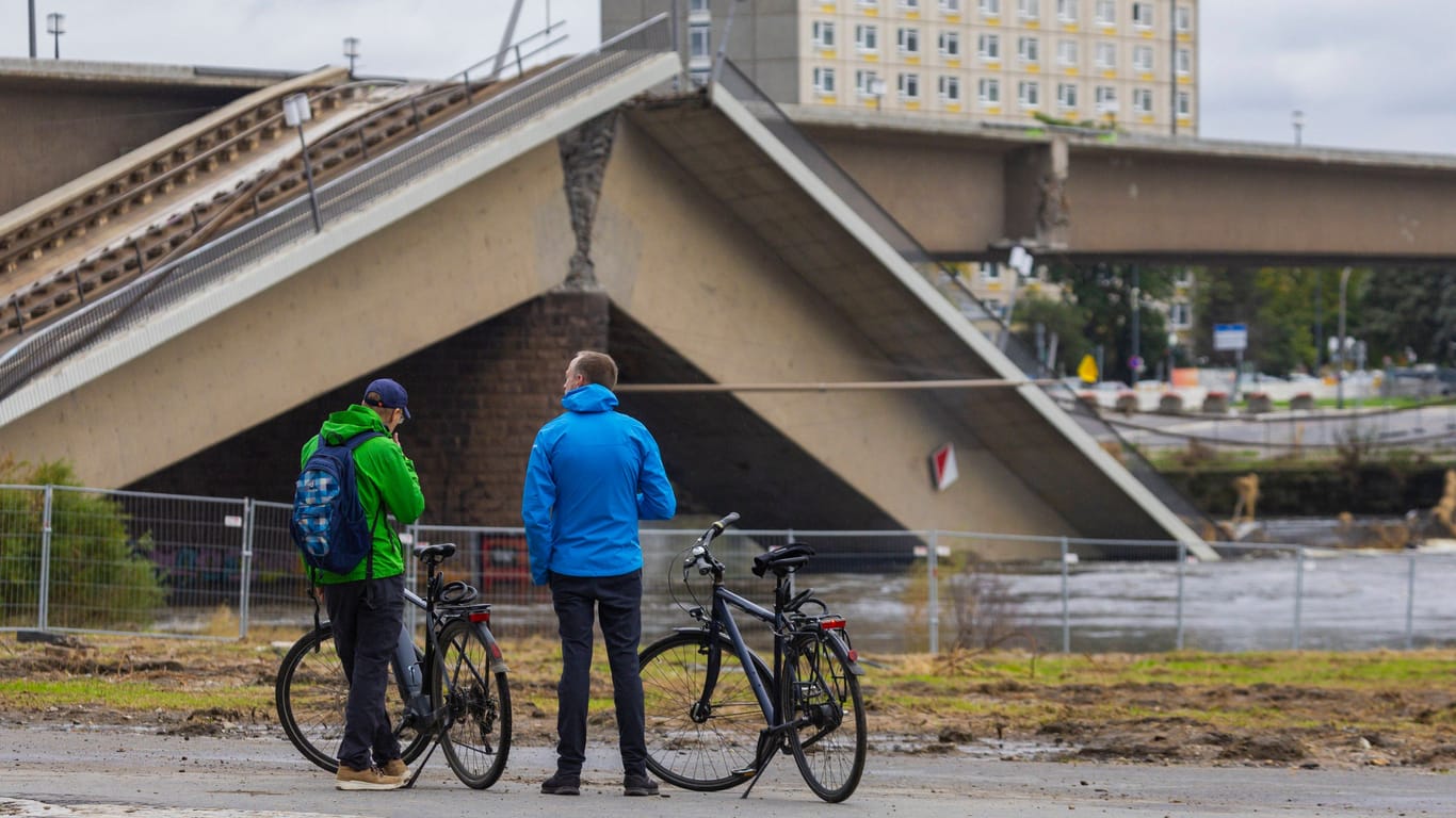 Zwei Radfahrer vor den Bauzäunen an der abgesperrten Carolabrücke (Archivbild):