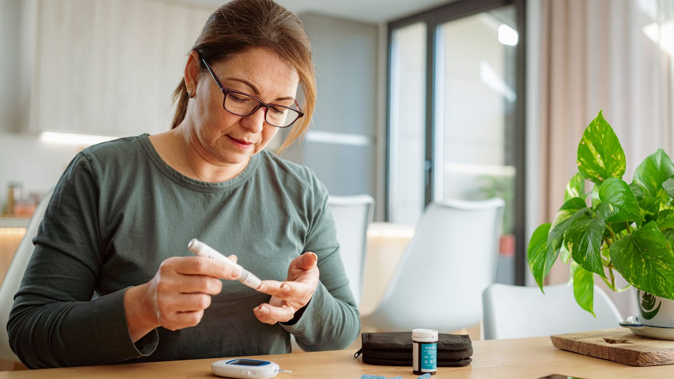 Frau misst ihren Blutzucker: Ein schlecht eingestellter Blutzuckerspiegel kann bei Diabetes Wundheilungsstörungen begünstigen.