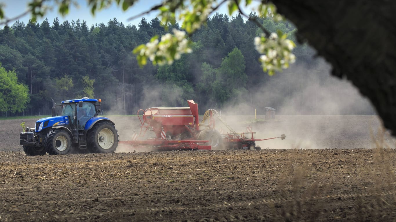 Ein Traktor fährt über einen Acker (Symbolbild): Um etwa einen Quadratmeter Ackerfläche zu schützen, wird in Nörvenich viel Aufwand betrieben.