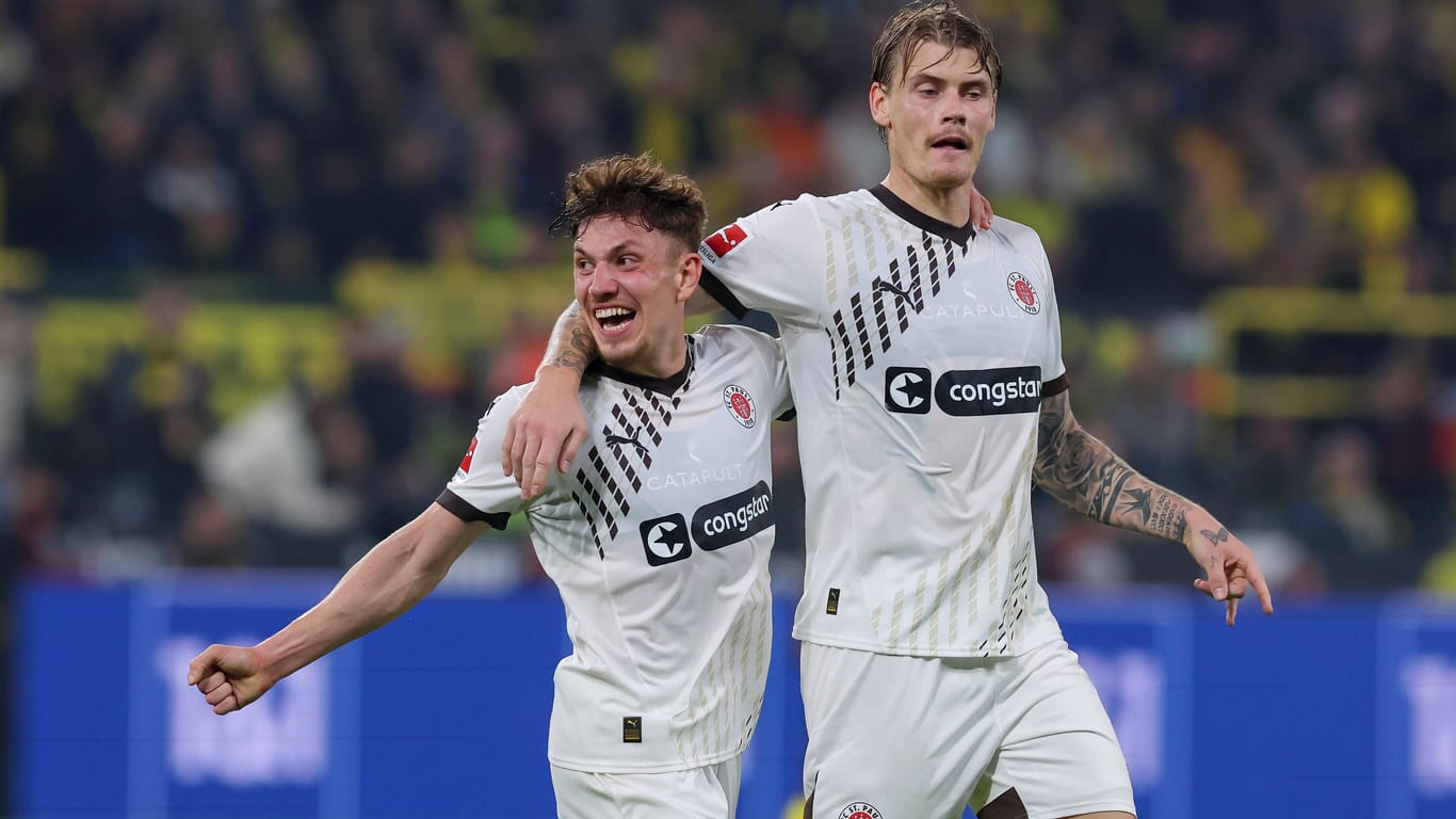 Philipp Treu (l.) jubelt mit Eric Smith über dessen Tor zum zwischenzeitlichen 1:1-Ausgleich bei der 1:2-Niederlage des FC St. Pauli bei Borussia Dortmund am 18. Oktober 2024.