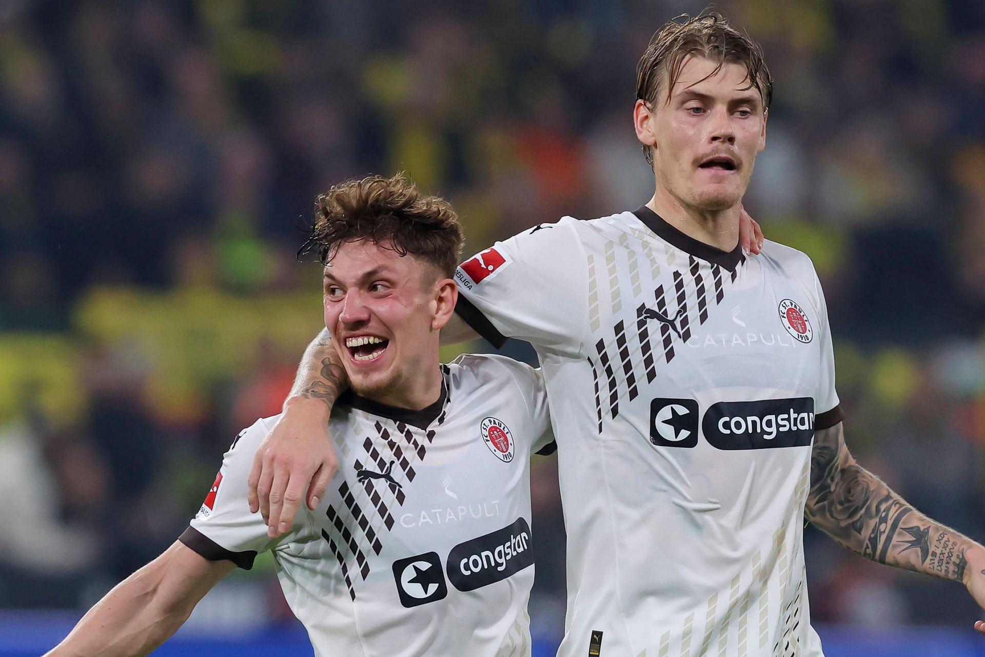 Philipp Treu (l.) jubelt mit Eric Smith über dessen Tor zum zwischenzeitlichen 1:1-Ausgleich bei der 1:2-Niederlage des FC St. Pauli bei Borussia Dortmund am 18. Oktober 2024.