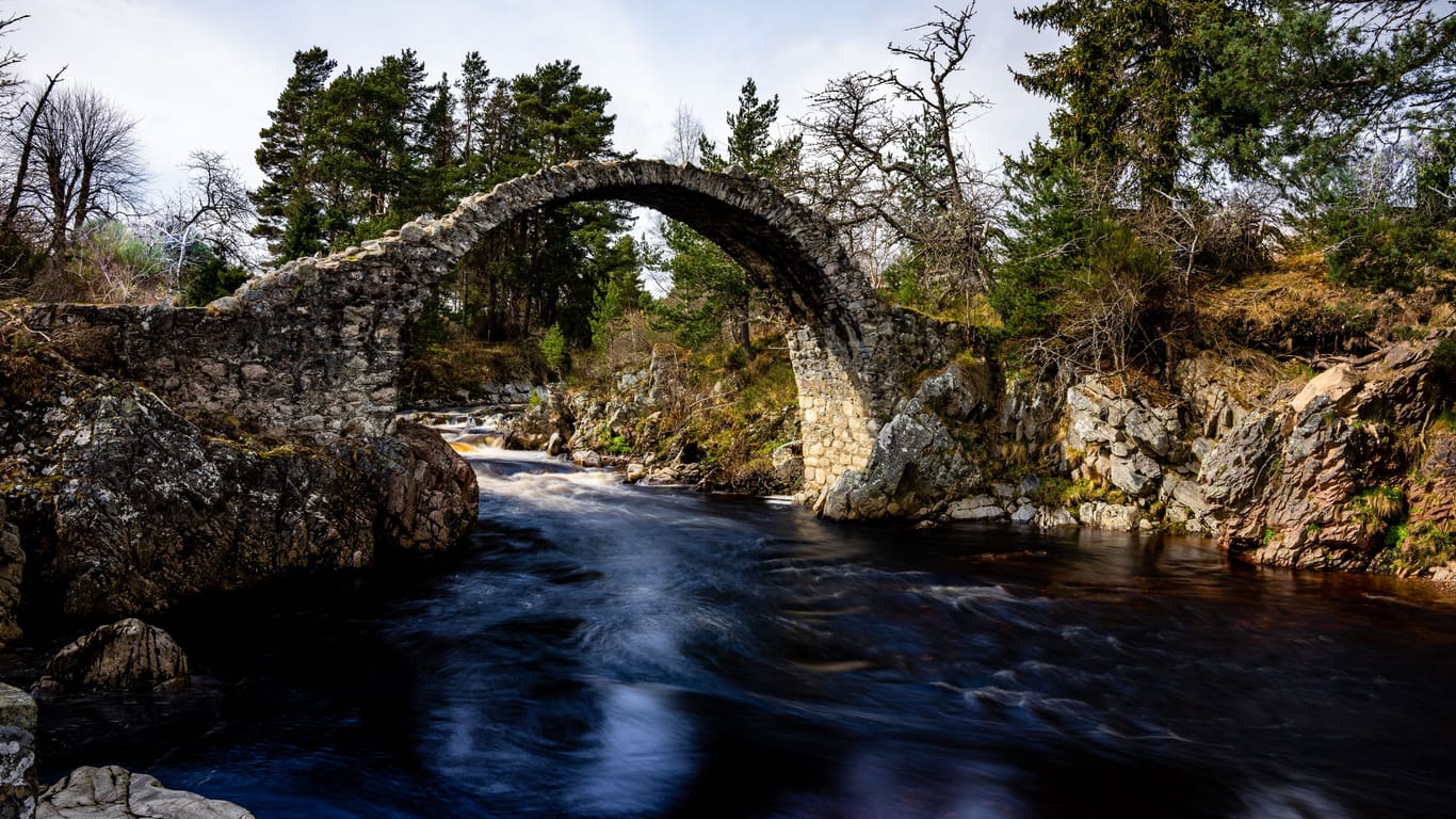 Die alte Packpferdbrücke über dem Fluss Dulnain in Schottland.