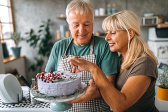 Ein Paar bereitet einen Kuchen zu.