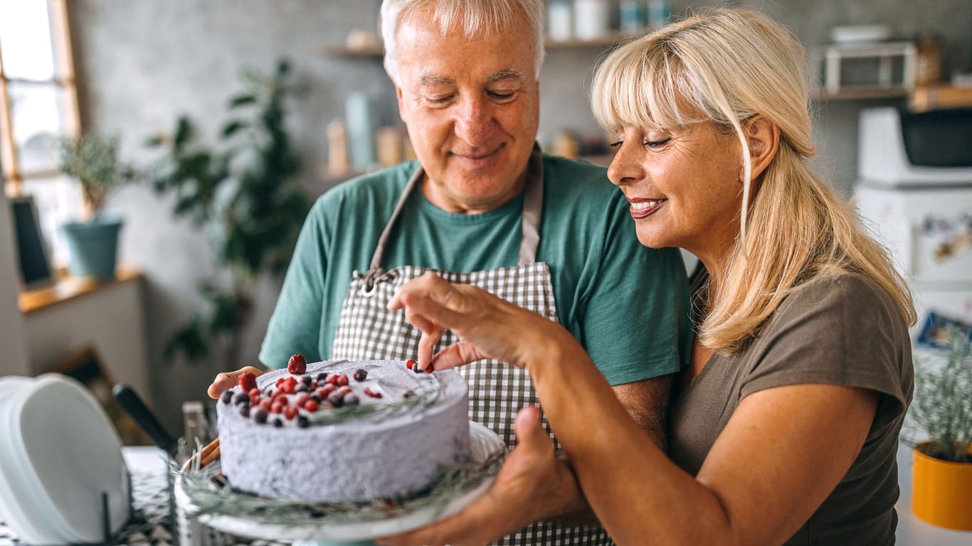 Ein Paar bereitet einen Kuchen zu.