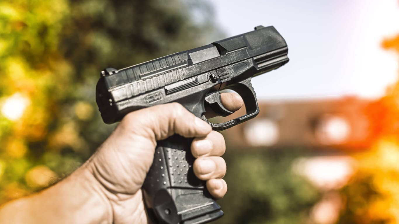 Ein Mann hält eine Schusswaffe in der Hand (Archivbild): In Berlin wurden zwei Personen angeschossen.