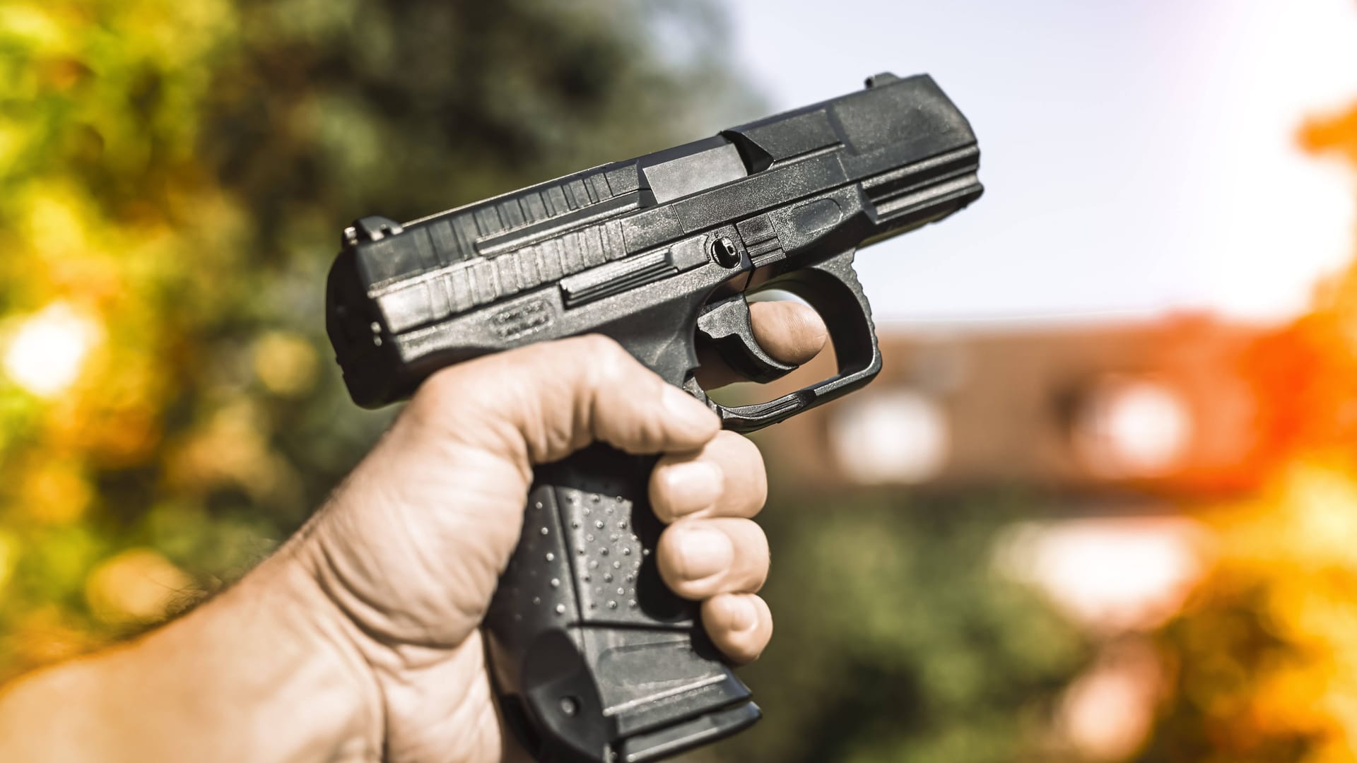 Ein Mann hält eine Schusswaffe in der Hand (Archivbild): In Berlin wurden zwei Personen angeschossen.