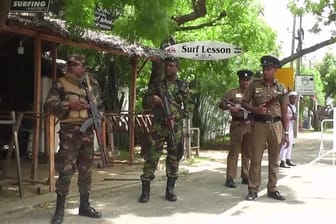 Polizisten stehen auf einer Straße in Sri Lanka.