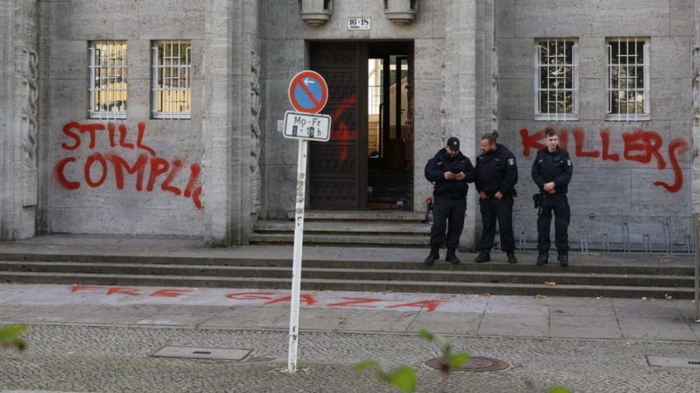 Einsatzkräfte der Polizei stehen vor einem Gebäude der Freien Universität in der Kaiserwerther Straße.