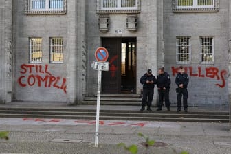 Einsatzkräfte der Polizei stehen vor einem Gebäude der Freien Universität in der Kaiserwerther Straße.