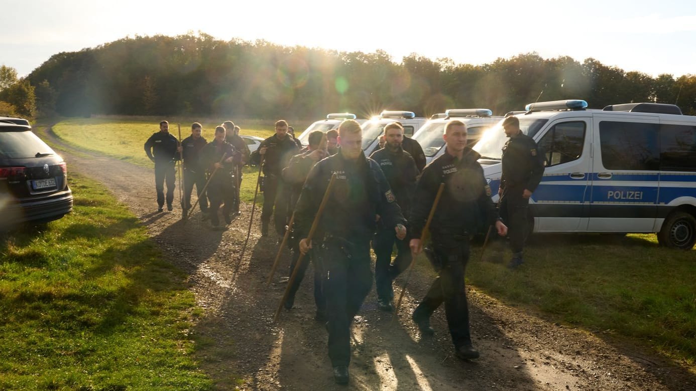 Polizisten suchen die Umgebung nach dem Fund von zwei Leichen ab.