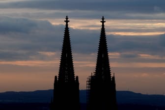 Die Spitzen des Kölner Doms bei Sonnenuntergang (Archivbild): Mehrere Unbekannte sind offenbar ohne Sicherung auf den höchsten Punkt des Kölner Wahrzeichens geklettert.