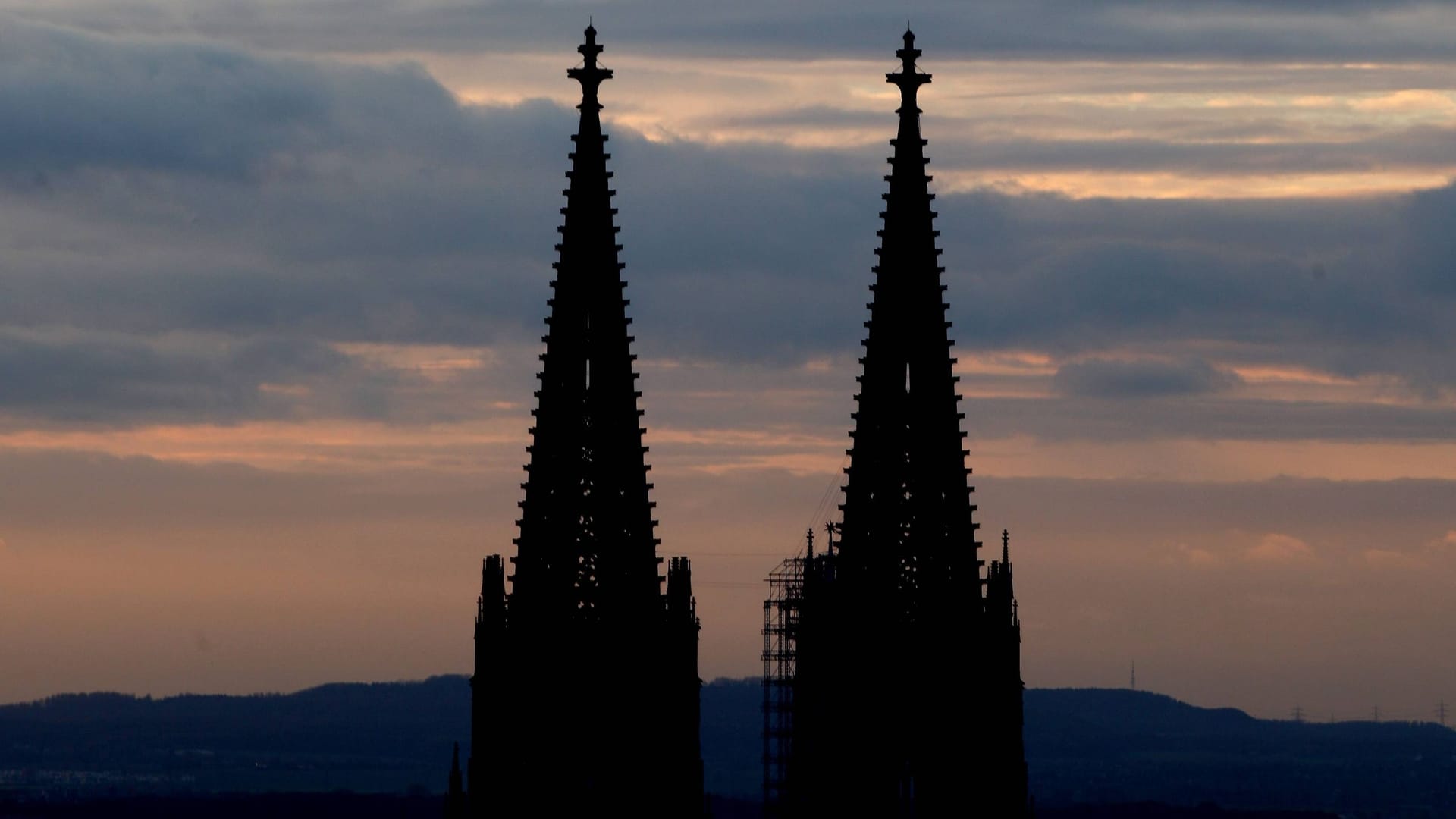 Die Spitzen des Kölner Doms bei Sonnenuntergang (Archivbild): Mehrere Unbekannte sind offenbar ohne Sicherung auf den höchsten Punkt des Kölner Wahrzeichens geklettert.