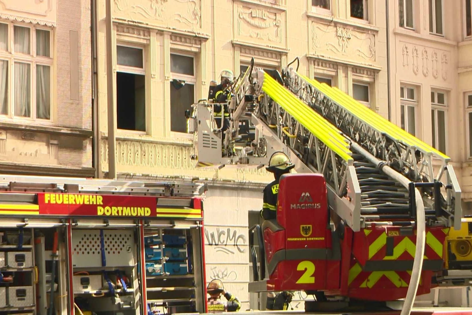 Am frühen Nachmittag des 04.10.2024 wurde der Leitstelle der Feuerwehr Dortmund ein Wohnungsbrand in einem Mehrfamilienhaus in der Bornstraße gemeldet. Umgehend wurden zwei Löschzüge der Berufsfeuerwehr, die zuständige Freiwillige Feuerwehr sowie der Rettungsdienst entsendet.Bei Eintreffen der ersten Kräfte schlugen auf der Gebäuderückseite des Mehrfamilienhauses bereits Flammen aus einem Balkonfenster im 1. Obergeschoss. Durch die hohe Brandintensität breitete sich der Brand auf die darüberliegenden Geschosse rasant aus. Außerdem drang Rauch in angrenzende Wohnungen des betroffenen Gebäudes sowie der beiden Nachbarhäuser ein.