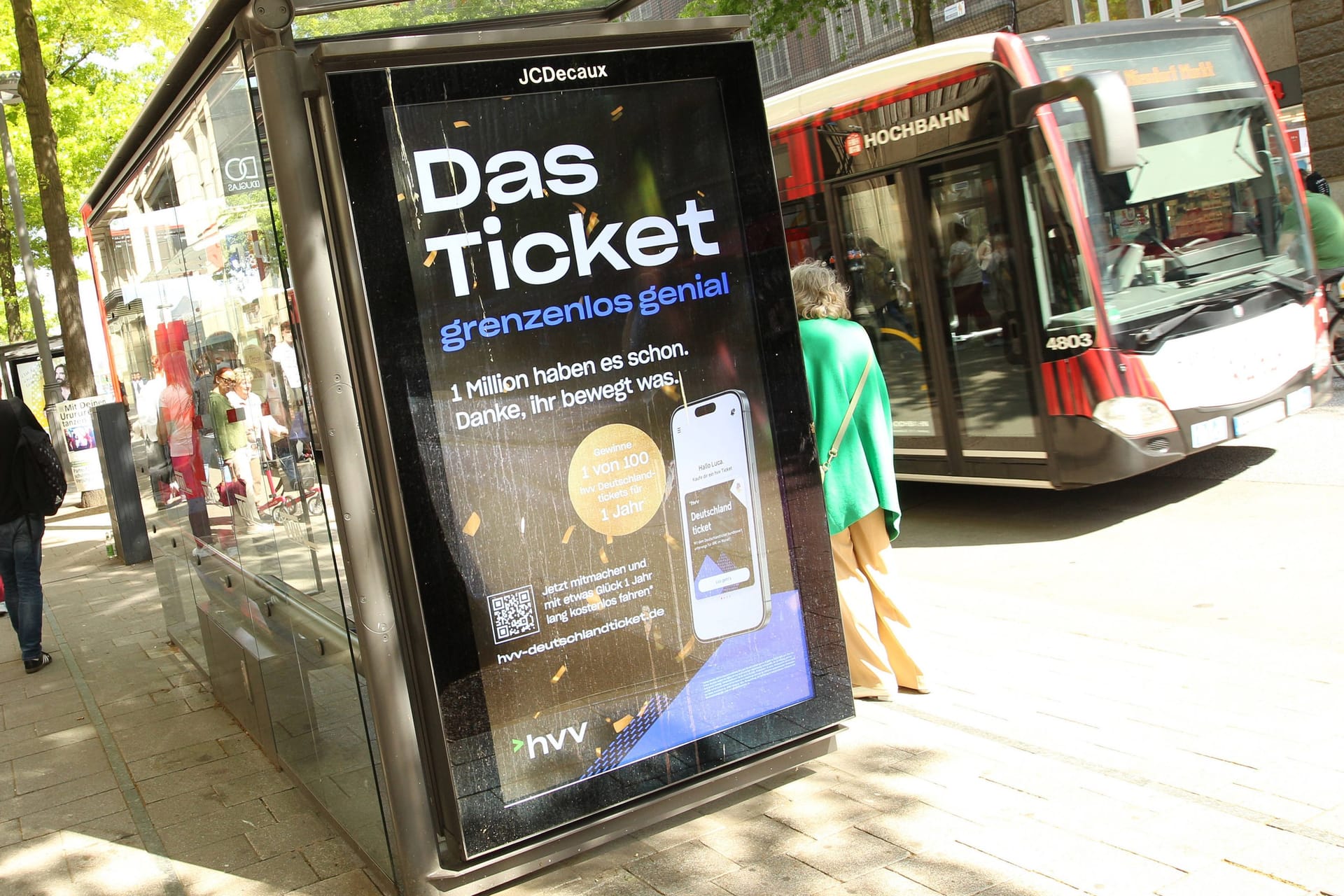 Ein HVV-Bus steht an einer Haltestelle. Dort ist eine Werbung für das Deutschlandticket zu sehen. (Symbolbild)