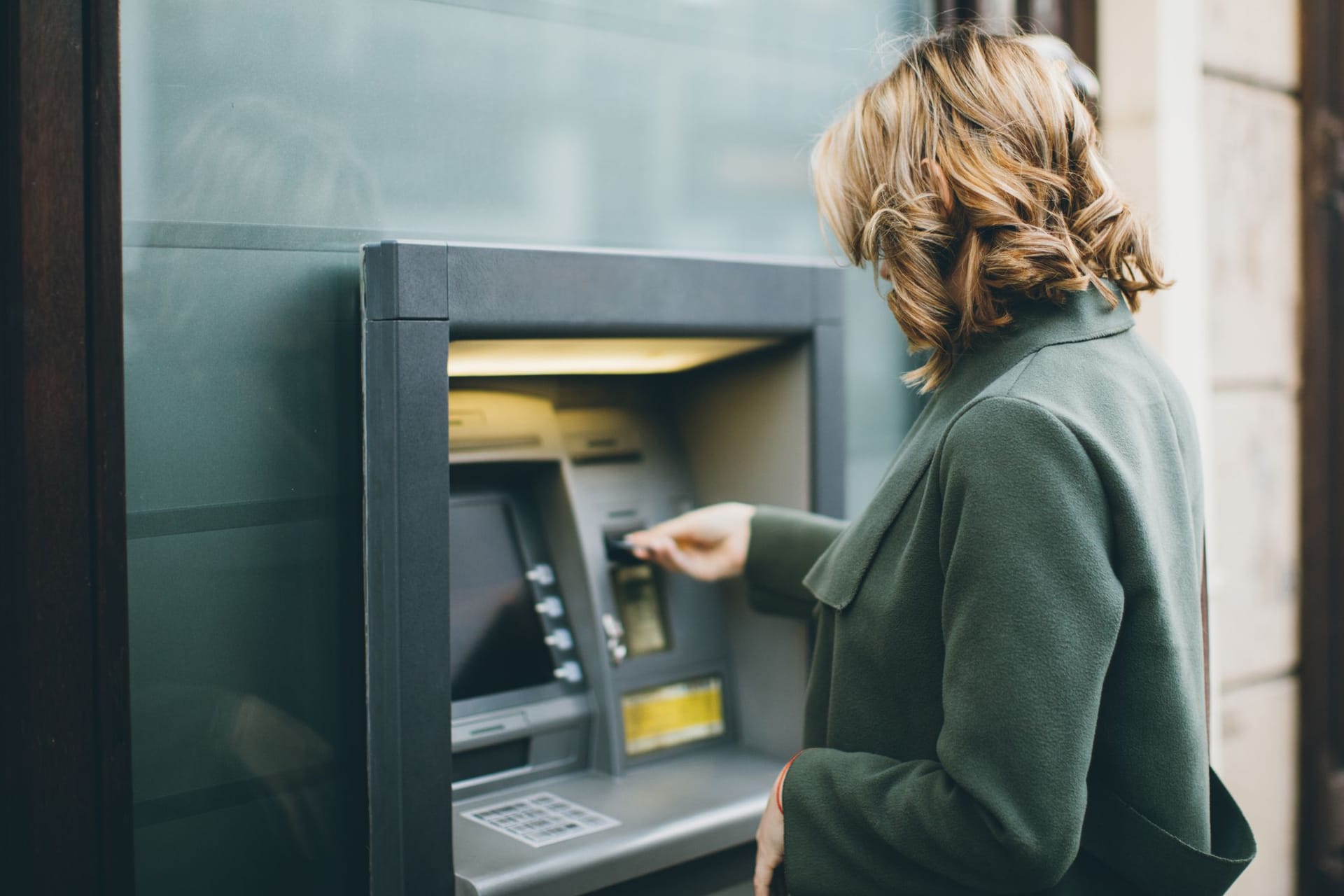 Frau hebt Geld an einem Geldautomaten ab