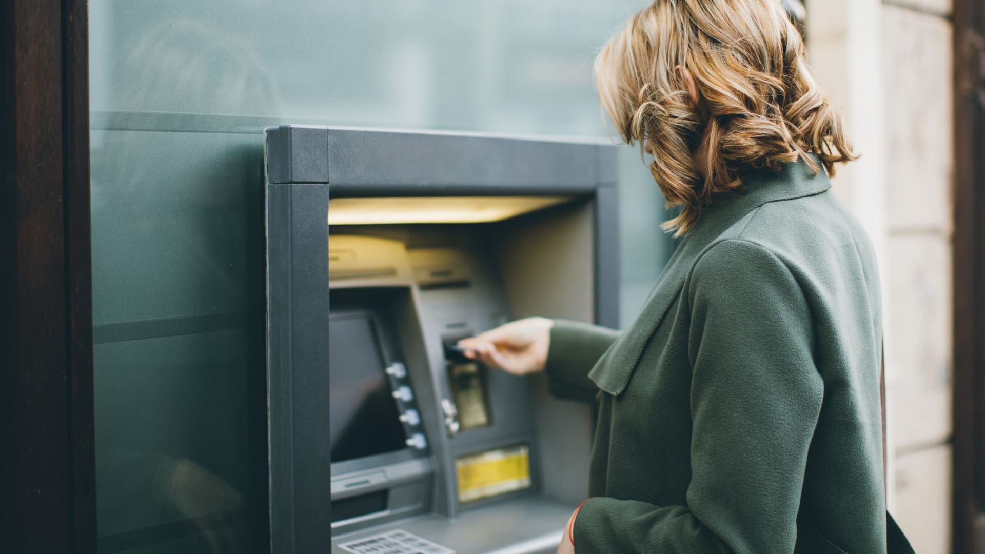 Frau hebt Geld an einem Geldautomaten ab