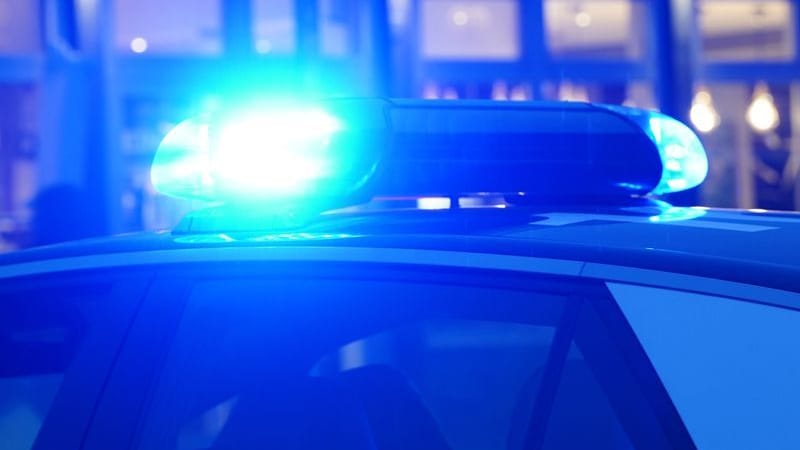 Ein Streifenwagen der Polizei steht mit eingeschaltetem Blaulicht an einem Einsatzort.