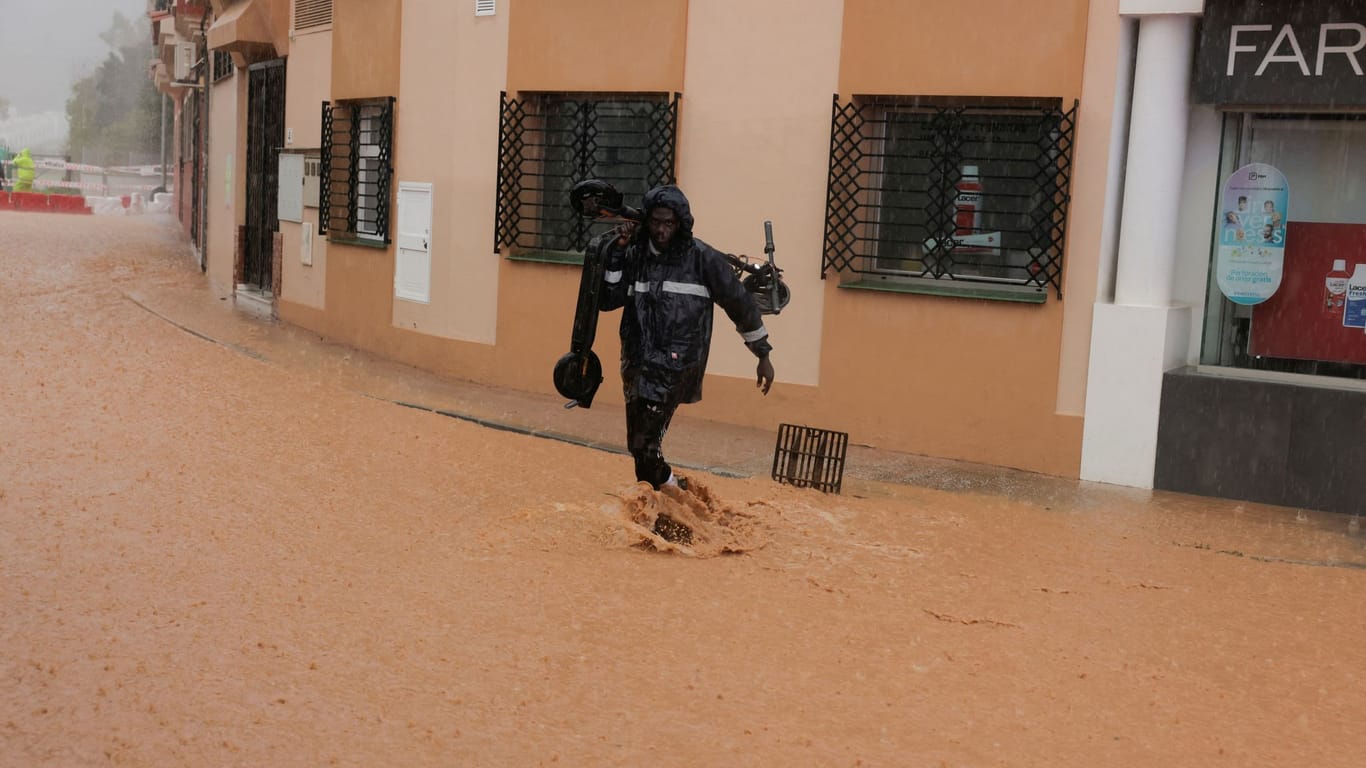 Ein Mann auf einer überfluteten Straße in Malaga: Erneut kam es in Spanien zu starken Regenfällen.