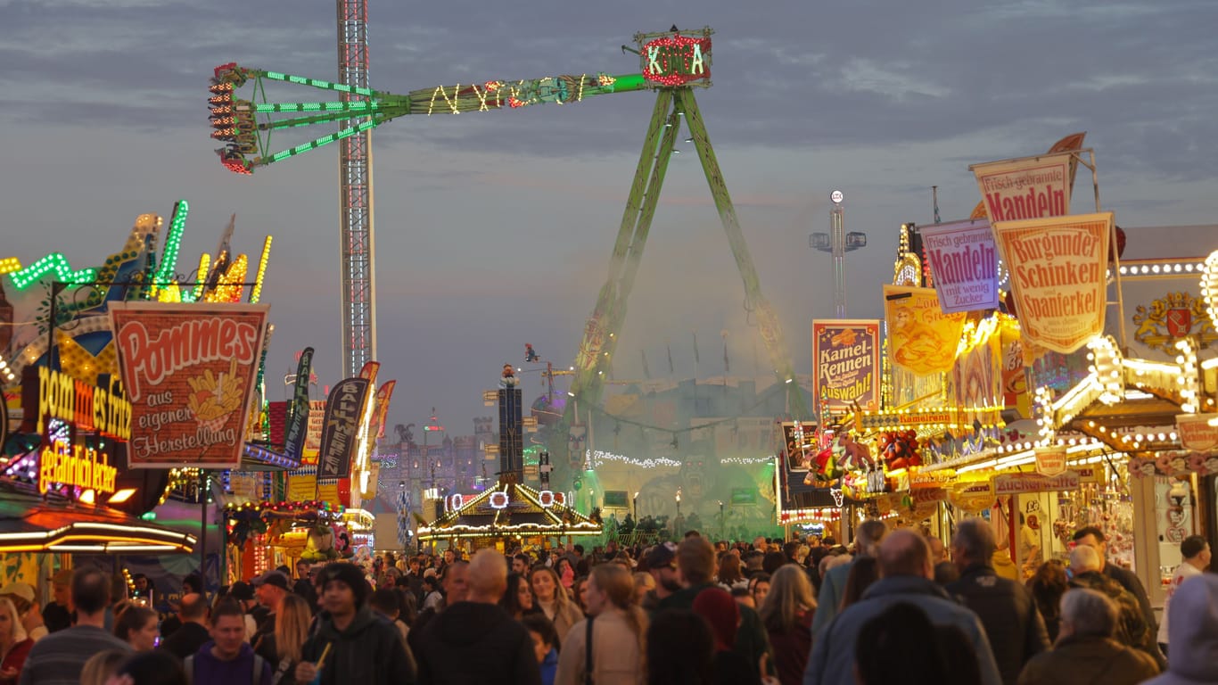 Besucher gehen zwischen Ständen und Fahrgeschäften auf dem 989. Freimarkt in Bremen: Die Bilanz zum Volksfest ist positiv.