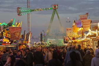 Besucher gehen zwischen Ständen und Fahrgeschäften auf dem 989. Freimarkt in Bremen: Die Bilanz zum Volksfest ist positiv.