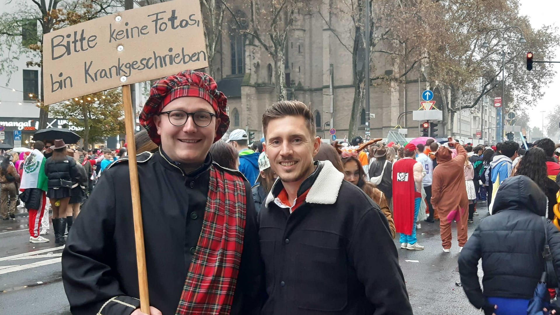 Karnevalisten Simon und Marcel (v.l.) auf der Zülpicher Straße: Obwohl sein Schild anderes besagt, lässt er Simon gerne fotografieren.