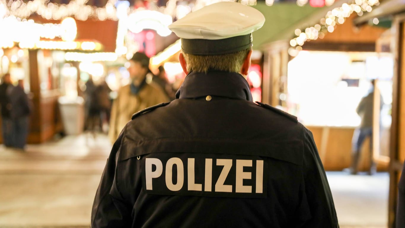 EIn Polizist geht über einen Weihnachtsmarkt (Symbolbild): In Elmshorn wurde ein Anschlag verhindert.