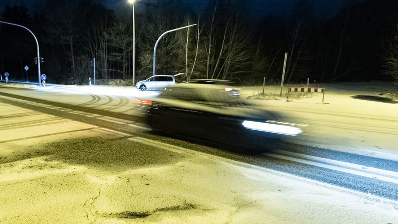 Ein Auto fährt über eine verschneite Kreuzung in Norderstedt bei Hamburg (Symbolbild):