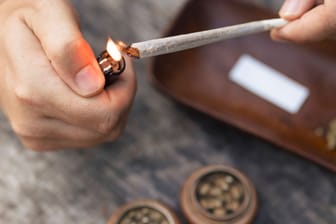 Eine Person zündet einen Joint an (Symbolbild): Wer in Niedersachsen gegen das Cannabisgesetz verstößt, soll hohe Straßen bezahlen müssen.